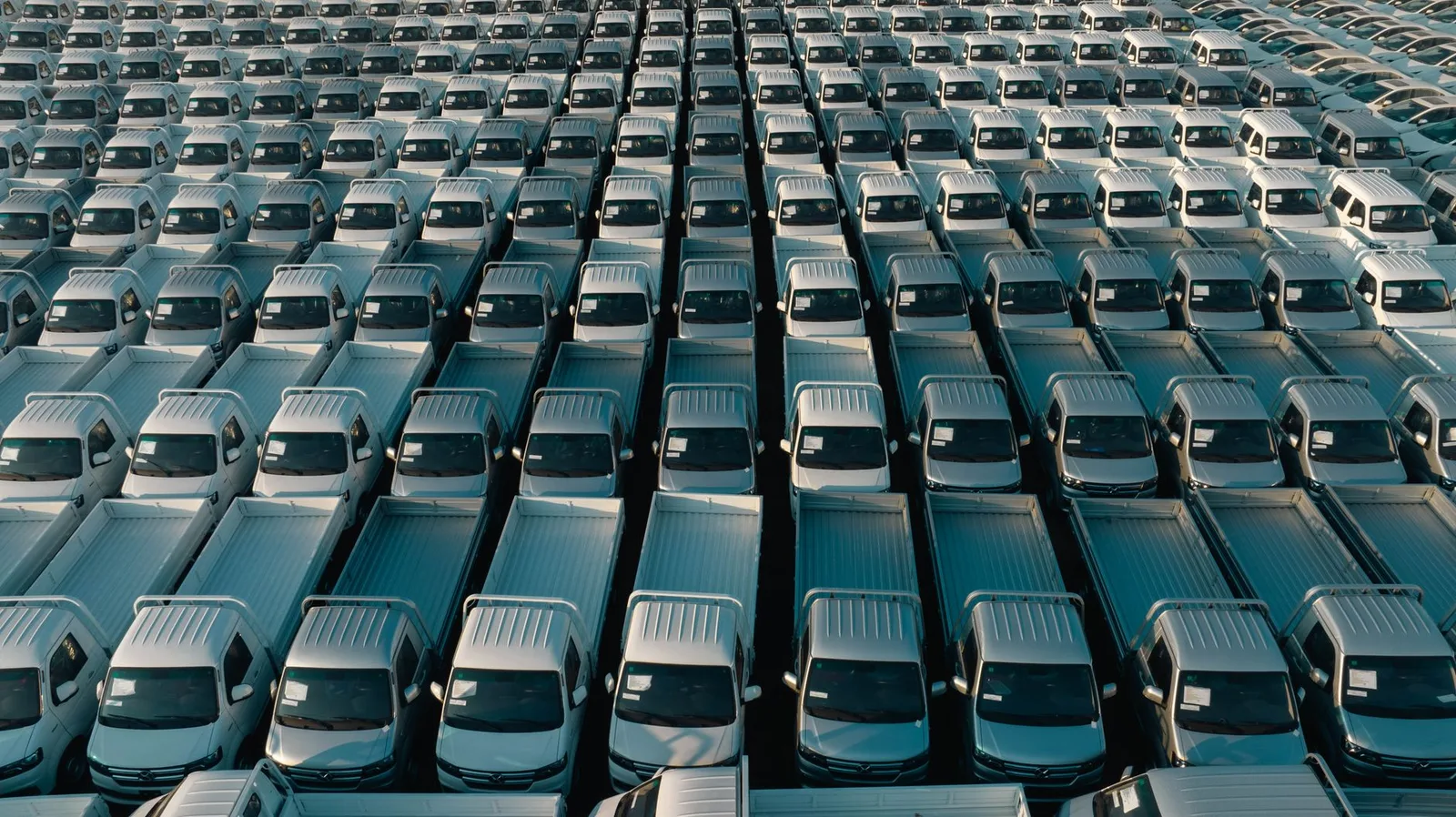 Technician servicing commercial trucks in a fleet yard